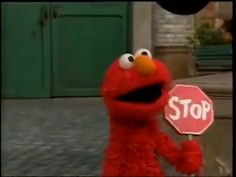 the sesame street character is holding a stop sign