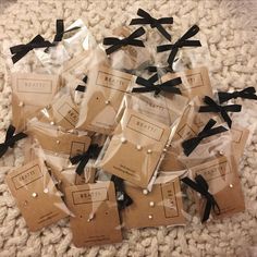 small packages with black bows are sitting on the carpet in front of some white and brown tags