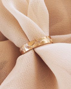 a gold ring sitting on top of a white cloth