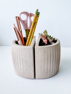 a cup with pencils, scissors and other office supplies in it