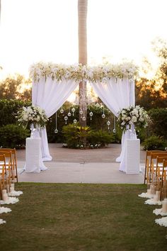 an outdoor wedding setup with white flowers and greenery