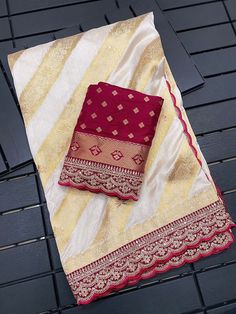 a red and white sari laying on top of a wooden table