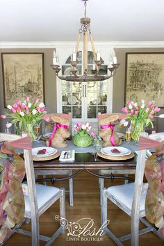 the dining room table is set with pink flowers