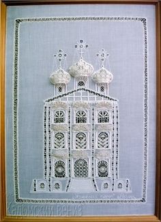 an embroidered picture in a wooden frame with white thread on the front and bottom part of it