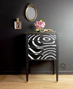 a black and white dresser with flowers on top