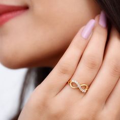 a close up of a woman's hand with a diamond ring on her finger