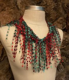 "Christmas scarf for women. Red and Green ladder yarn scarf necklace with sparkle for the holidays. Unique gift for women who has everything.  Dress up your holiday outfit with this beautiful fringe scarf with a nice bling. There is no teal in the green if your screen shows teal, it's gradient emerald green.  This is about 70\" long traditional scarf with well structured body.  Hand wash in lukewarm water with mild soap, don't rub or wring, squeeze of excess water and hang to dry.  Comes with nice organza satchel for traveling, storage or gift giving. Store the ribbon scarves flat in a drawer or hang them up.  Handmade in United States of America.  Visit my store front at  www.Etsy.com/shop/thinkerbella for more color and design options.  Free shipping on orders over $35. Just add all the Red Scarves For Gifts, Red Winter Scarves For Gifts, Red Winter Scarf Gift, Red Winter Scarves Perfect For Gifts, Red Winter Scarf Perfect For Gifts, Red Bohemian Scarf As Gift, Handmade Red Scarf As A Gift, Handmade Red Scarves As Gift, Handmade Red Scarf For Gift