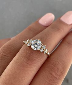 a woman's hand with a diamond ring on top of her finger and an engagement band