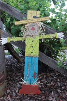 a scarecrow made out of wood sitting on the ground