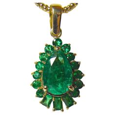 This is a 5.20-carat vibrant AAA green natural Colombian emerald drop pendant necklace crafted in 18K yellow gold. The center emerald is a pear cut weighing over 4.0 carats and is surrounded by 1.20 carats of emeralds. The pendant measurements are 25.00mm x 15.40mm, rising 7.00mm. The average color/clarity is an intense fine green 100% NATURAL color/ clarity VS. **We'll include a chain(different from the ones pictured). 100% Natural Colombian Emeralds and 18K Yellow Gold handmade from our Worksh