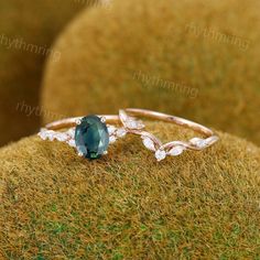 a close up view of a ring with an oval blue stone in the center and leaves around it