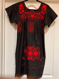 This fabulous Puebla black dress is hand made and hand embroidered  red floral design! Great spring and summer dress as well as topping it off with a jean jacket for the fall! 80% Cotton 20% Polyester Measurements! Pic 1  Small Chest:  34" Length:  35" Hip:  44" Pic 2 Medium Chest:      40" Length:    36" Hip:          48" Pic 3   Large  Chest:      40" Length:    34" Hip:          48" Pic 4      XLarge Chest:      44" Length:    36" Hip:          50" Pic 5      XLarge  Chest:      44" Length: Red Embroidered Casual Fitted Dress, Red Fitted Embroidered Casual Dress, Red Embroidered Fitted Casual Dress, Casual Red Fitted Embroidered Dress, Black Cotton Folk Embroidered Dress, Casual Red Embroidered Dress, Black Folk Dress With Floral Embroidery, Black Cotton Embroidered Dress With Floral Embroidery, Black Cotton Dress With Floral Embroidery