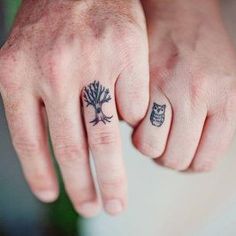 two people with tattoos on their fingers holding each other's hands and one has an owl