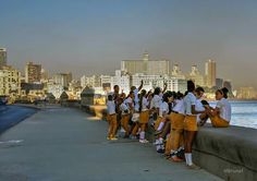 a group of people standing next to each other on a bridge over looking the water