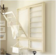 a bathroom with white cabinets and towels hanging on the wall