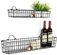 two black metal baskets holding wine bottles and flowers on the wall, one with a flower pot in it