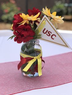 red and yellow flowers in a glass jar with a us flag on the table top