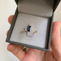 a person holding an open box with a ring in it's left hand,