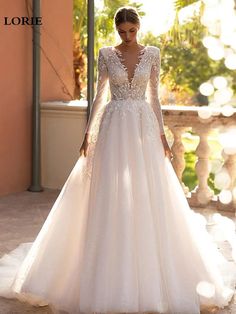 a woman in a white wedding dress standing on a balcony with her hands behind her back