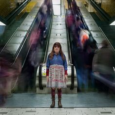 a woman standing in front of an escalator