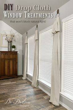 an image of a room with white curtains on the windows and wood floors in it