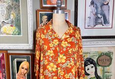 1980's Hawaiian Print Shirt by Puritan Burnt Orange with Yellow, Green and White Floral Design  100% Rayon 7 Front Buttons 1 Front Pocket MEASUREMENTS (in inches):                                                                                                                    Shoulder to Shoulder (back): 22"Chest: 54" Side Length (armpit to hem)15" Arm Length (armpit to cuff): 7" Neck Opening: 18" Neck to Hem (back): 30" INTERNATIONAL CUSTOMER?? Please email for Shipping Info Vintage Camp Collar Blouse For Summer, Vintage Tops With Camp Collar For Spring, Vintage Printed Hawaiian Shirt For Spring, Vintage Collared Hawaiian Shirt For Spring, Spring Vintage Hawaiian Shirt With Retro Print, Vintage Orange Blouse For Summer, Vintage Hawaiian Shirt With Floral Print, Retro Yellow Hawaiian Shirt With Camp Collar, Yellow Button-up Hawaiian Shirt For Spring