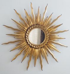 a sun shaped mirror hanging on the wall