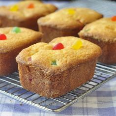 several muffins on a cooling rack with gummy bears in the top one