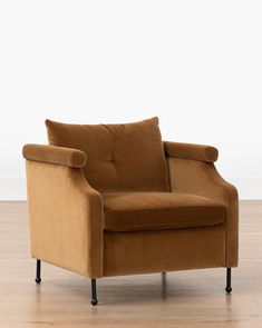 a brown chair sitting on top of a hard wood floor next to a white wall