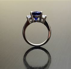 Dekara Designs Collection Metal- 90% Platinum, 10% Iridium. Stones- 1 Natural Untreated 3.88 Carat Oval Cut Ceylon Blue Sapphire. 2 Moon Cut Diamonds, F-G Color VS1 Clarity 0.77 total carats This ring is a size 6, but could be sized up or down a few sizes. This ring could be made in your specific size within 5-10 business days. Could take a little more time due to the ceylon sapphire being a rare stone. The sapphire may be a bit smaller or bigger. We can make the same design in a smaller or bigg Formal Blue Sapphire Ring Gia Certified, Blue Tanzanite Diamond Ring With Accent Stones, Blue Sapphire Three-stone Promise Ring, Blue Tanzanite Ring With Trillion Cut, Blue Three Stone Sapphire Promise Ring, Classic Blue Rings With Halo Setting, Formal Blue Lab-created Sapphire Diamond Ring, Blue Sapphire Ring With Trillion Cut Diamond, Trillion Cut Blue Sapphire Ring With Diamond