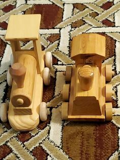 two wooden toy cars sitting on top of a rug