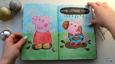 a person is holding an open book with peppa pig on it and another drawing in the background