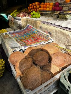 coconuts and other fruits are on display at an outdoor market