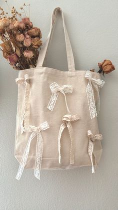 a handbag hanging on the wall next to dried flowers