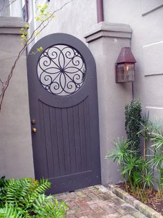 an entrance to a house with a decorative door and brick walkway leading up to it