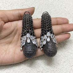 Black Diamond Earrings featuring semi precious black stone with cubic zirconia. Ideal to pair with your formals and statement look. These PREMIUM QIUALITY black sapphire CZ Earrings are surely elevate your look and give you a LUXURY look. Perfect gift for Her *𝐏𝐑𝐎𝐃𝐔𝐂𝐓 𝐃𝐄𝐓𝐀𝐈𝐋* * 𝐌𝐚𝐭𝐞𝐫𝐢𝐚𝐥: Brass * 𝐏𝐥𝐚𝐭𝐢𝐧𝐠: White Rhodium Plated * 𝐒𝐭𝐨𝐧𝐞: AAA-quality CZ Diamond. *𝐃𝐈𝐌𝐄𝐍𝐒𝐈𝐎𝐍𝐒* * 𝐖𝐞𝐢𝐠𝐡𝐭: 24 gm each * 𝐋𝐞𝐧𝐠𝐭𝐡: 6.8 cm * 𝐖𝐢𝐝𝐭𝐡:  1.4 cm * 𝐂𝐥𝐨𝐬𝐮 Black Diamond Earrings For Wedding, Black Diamond Earrings For Party, Black Cubic Zirconia Earrings For Evening, Black Teardrop Jewelry With Rhinestones, Black Teardrop Rhinestone Jewelry, Black Crystal Chandelier Earrings For Party, Black Cubic Zirconia Jewelry With Sparkling Stones, Black Earrings With Sparkling Stones For Party, Black Drop Crystal Earrings