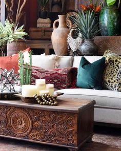 a living room filled with lots of different types of pillows and decor on top of a wooden table