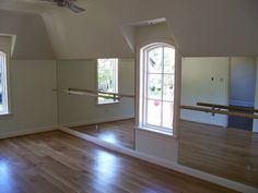 an empty room with wooden floors and windows