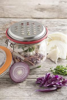 a jar filled with vegetables sitting on top of a wooden table