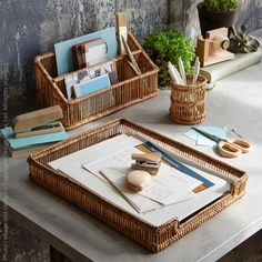 two wicker trays sitting on top of a table next to books and papers