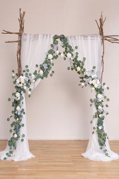 an arch decorated with greenery and white flowers