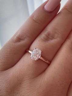 a woman's hand with a ring on it and a diamond in the middle