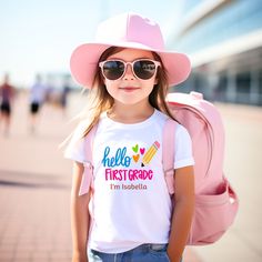 First Grade Back to School Shirt Colorful Hello 1st Grade Custom Outfit First Day of School Gift for Girl Back to School Tee for Teacher DETAILS Super Soft and Comfortable Gildan 3322 Rabbit Skins for Toddler Flatlock-stitched seams Shoulder-to-shoulder self-fabric back neck tape PERSONALIZATION We know that customized orders may make you more happy. So we love customization. You can add a personal touch to our designs. If you would like to add additional text to back or front, please add this p Pink T-shirt With Name Print For School, Cute Multicolor T-shirt With Name Print, Birthday Crew Neck T-shirt For Back To School, Fun T-shirt For Back To School, Cute Tops For Birthday And Back To School, Cute Multicolor T-shirt For Back To School, Pink Slogan T-shirt For School, Cute White T-shirt For Back To School, Outfit First Day Of School