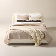 a bed with two pillows and blankets on it