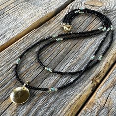 Dainty Double Strand Beaded Necklace with Black Czech Glass Beads and a Round Gold Pendant: Beads: * Black Czech Glass - 2mm * Turquoise Czech Glass Seed Beads - 2mm * 14K Gold Filled Spacer Beads - 2mm Pendant: * Round 10K Gold Plated Pendant  - 14mm Clasp: *14K Gold Filled Lobster Clasp  * The model in the pictures is wearing 16 & 18 inches.  Choose your Lengths at Checkout! If you don't see a certain length in the drop down menu, please message me with the lengths you would like :)  To view m Black Beads With Gold Details For Festival, Beach Jewelry With Gold And Black Beads, Gold Jewelry With Black Beads For The Beach, Elegant Beach Jewelry With Black Beads, Elegant Black Beads Beach Jewelry, Elegant Black Beads Jewelry For Beach, Black And Gold Beads For Festival, Black Beaded Necklaces With Gold Beads For Festival, Black Beaded Necklace For Beach With Tiny Beads