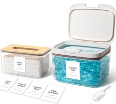 there is a lunch box with blue beads in it and four labels on the lid