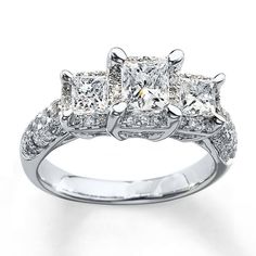 three stone engagement ring with princess cut diamonds on the sides and side stones set in white gold