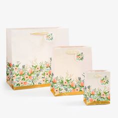 three bags with flowers on them are sitting next to each other in front of a white background