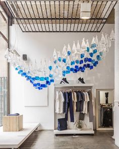 a room filled with lots of clothes and chandelier hanging from the ceiling above