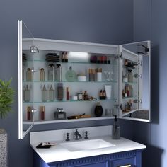 a bathroom with blue cabinets and shelves filled with personal care items on the wall above the sink